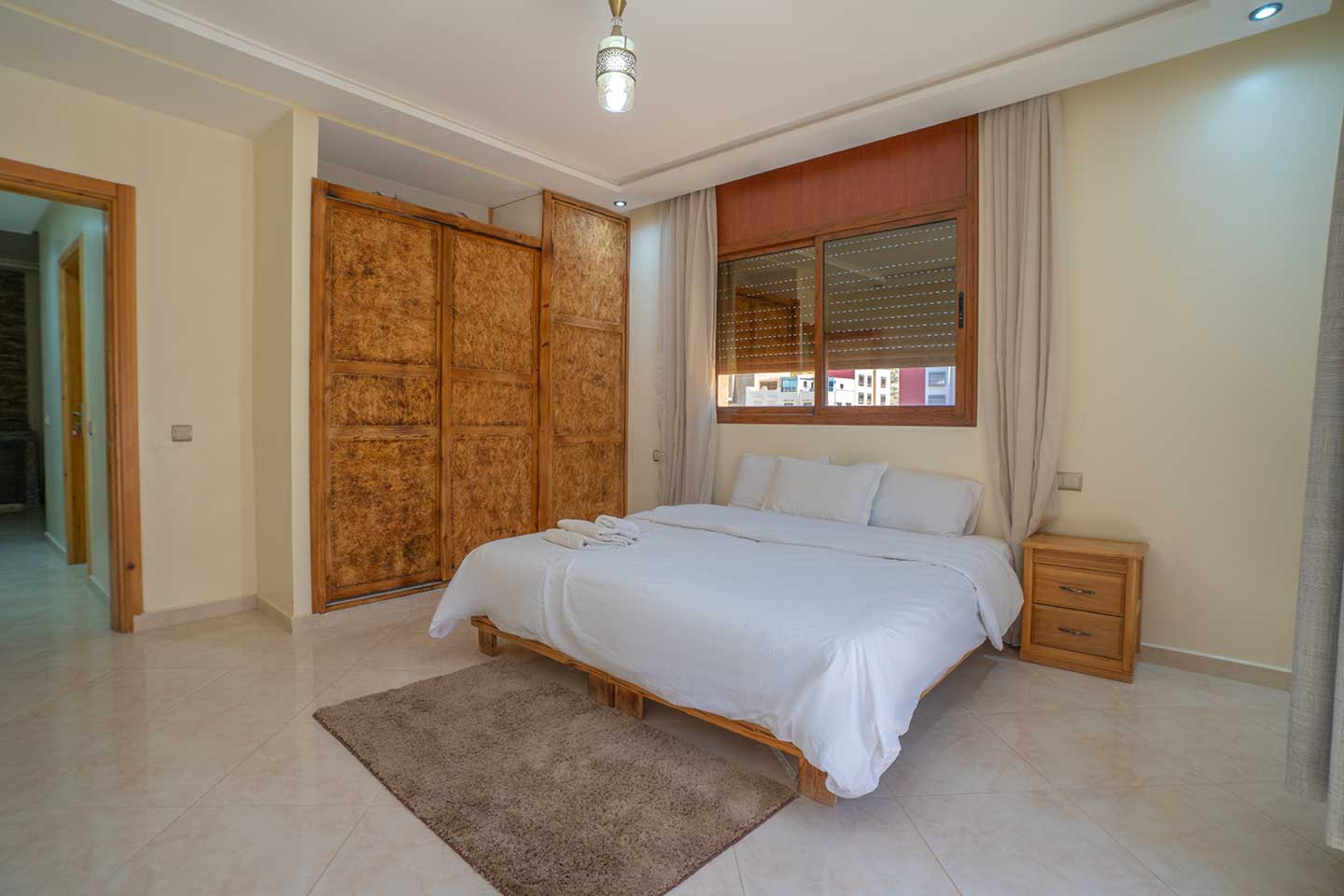 King bedroom with large bed and private balcony at Golden Wave surf camp
